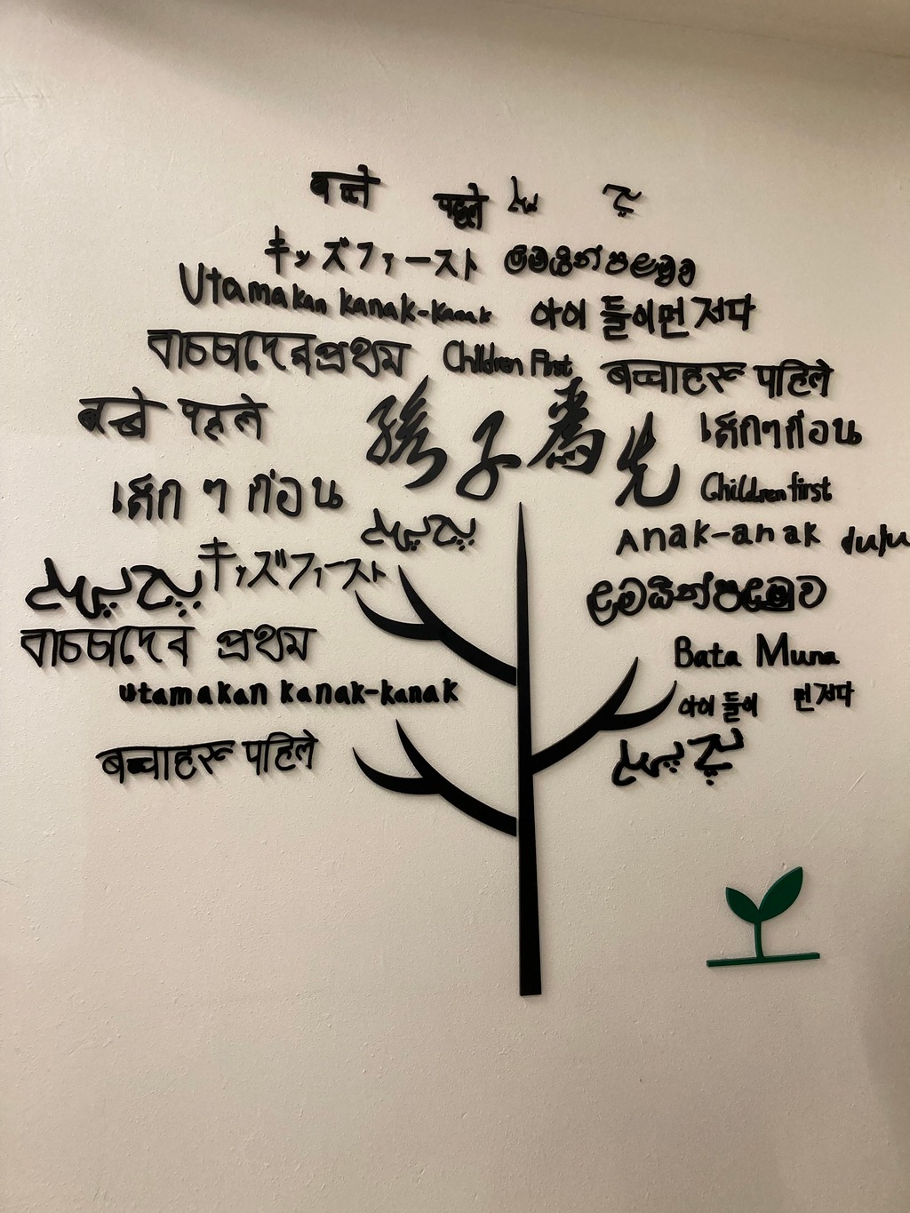 「孩子為先」是學校的辦學理念，牆上的字由校內不同國籍的同學合作撰寫13種「孩子為先」的譯文。